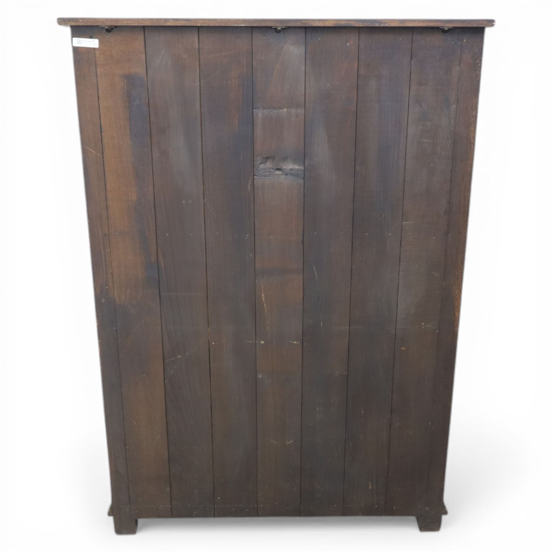  Late 20th century oak four door cupboard in the manner of Titchmarsh and Goodwin, rectangular plank top above two pairs of fielded panel doors with shaped raised panels, central arrangement of a brushing slide above two short drawers with brass swan neck handles and pierced backplates, enclosed by further pair of panelled cupboard doors, fitted with brass butt hinges and turned wooden knobs, raised on plinth base