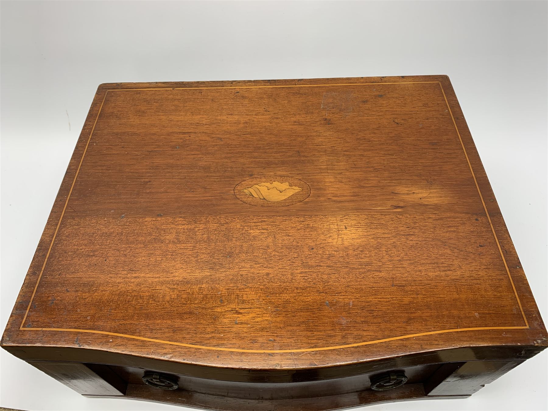 Late 19th/early 20th century composite canteen of silver flatware, contained within an early 20th century mahogany serpentine fronted case with twin drop carry handles, and hinged cover with boxwood stringing and central inlaid shell motif, above a single drawer with twin ring handles and Wellington style locking system, the cover and drawer opening to reveal plaque for Spink & Sons Ltd London, and fitted interior containing ivory handled knives, ivory handled carving set, and silver Hanoverian and Old English pattern cutlery, each with engraved monogram to terminal, hallmarked London, makers Spink & Son (John Marshall Spink), Goldsmiths & Silversmiths Co, and Chawner & Co (George William Adams), various dates ranging 1880-1923, gross weighable silver 92.59 ozt (2880 grams)