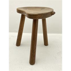 'Mouseman' oak three legged stool with dished kidney shaped seat, tapered octagonal supports, with carved mouse signature, by Robert Thompson of Kilburn 