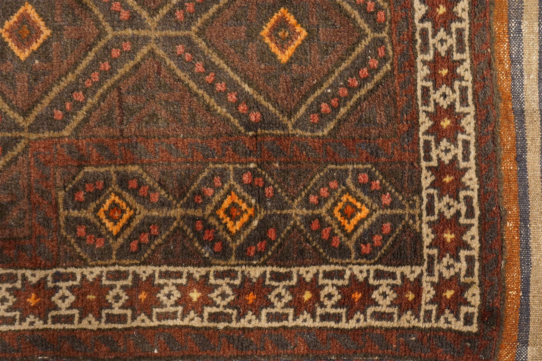Two hand-knotted rugs, comprising Persian medallion rug and tribal rug, Persian hand-knotted rug, ivory ground centred by shaped floral medallion with pendants, surrounded by stylised flowerheads and foliate motifs, enclosed by multiple floral and geometric borders, H155cm, W123cm; tribal hand-knotted rug, dark brown ground with repeating linked geometric diamond medallions in orange and green, enclosed by ivory geometric border, striped ends with fringes, H150cm, W71cm