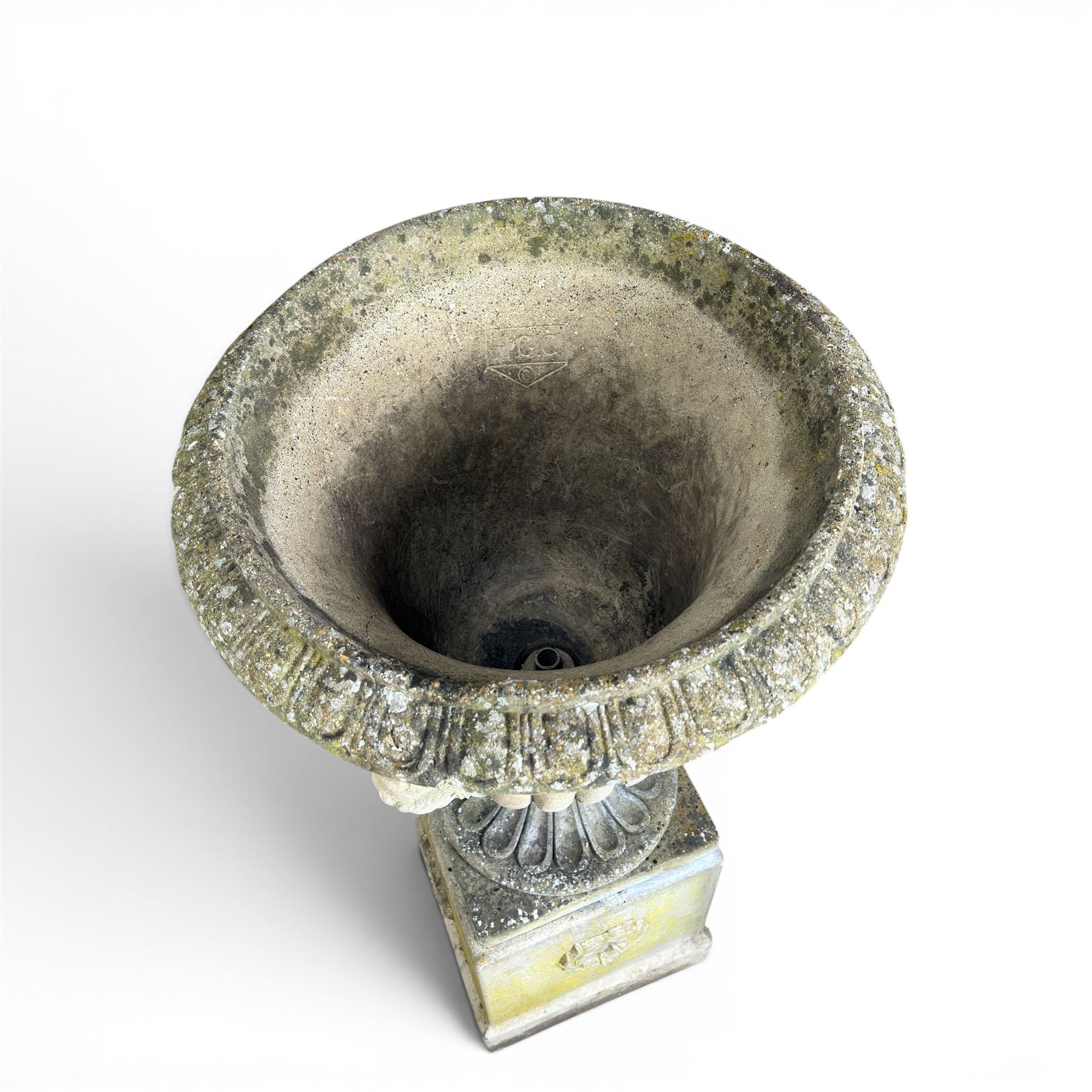 Cast stone classic garden urn, the rim decorated with leaves and berries, twin handles with face masks, raised on square base, stamped HGC