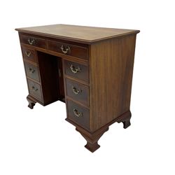 George III style mahogany kneehole desk, moulded rectangular top over eight cockbeaded drawers and central recessed cupboard, ornate cast metal handles and escutcheon, lower moulded over ogee bracket feet
