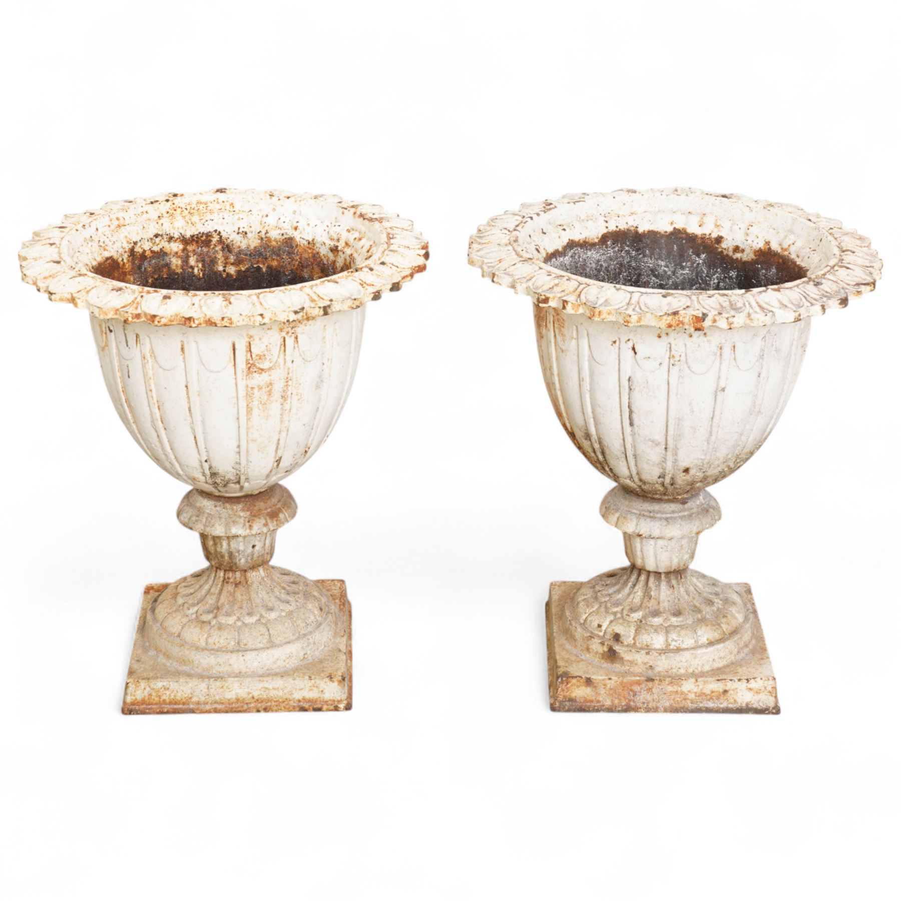 Pair of Victorian white painted cast iron lotus garden urns on stop fluted and lobed plinth bases