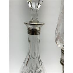 A clear glass silver mounted decanter, of baluster form, the silver collar with engraved dedication, hallmarked Dix Jewellery Ltd, London import 1985, including stopper H37.5cm, together with a silver and etched glass candle lamp, the spreading filled base supporting a frilled clear glass shade decorated with vines, hallmarked Reid & Sons Ltd, Birmingham 1981, H38.5cm. 