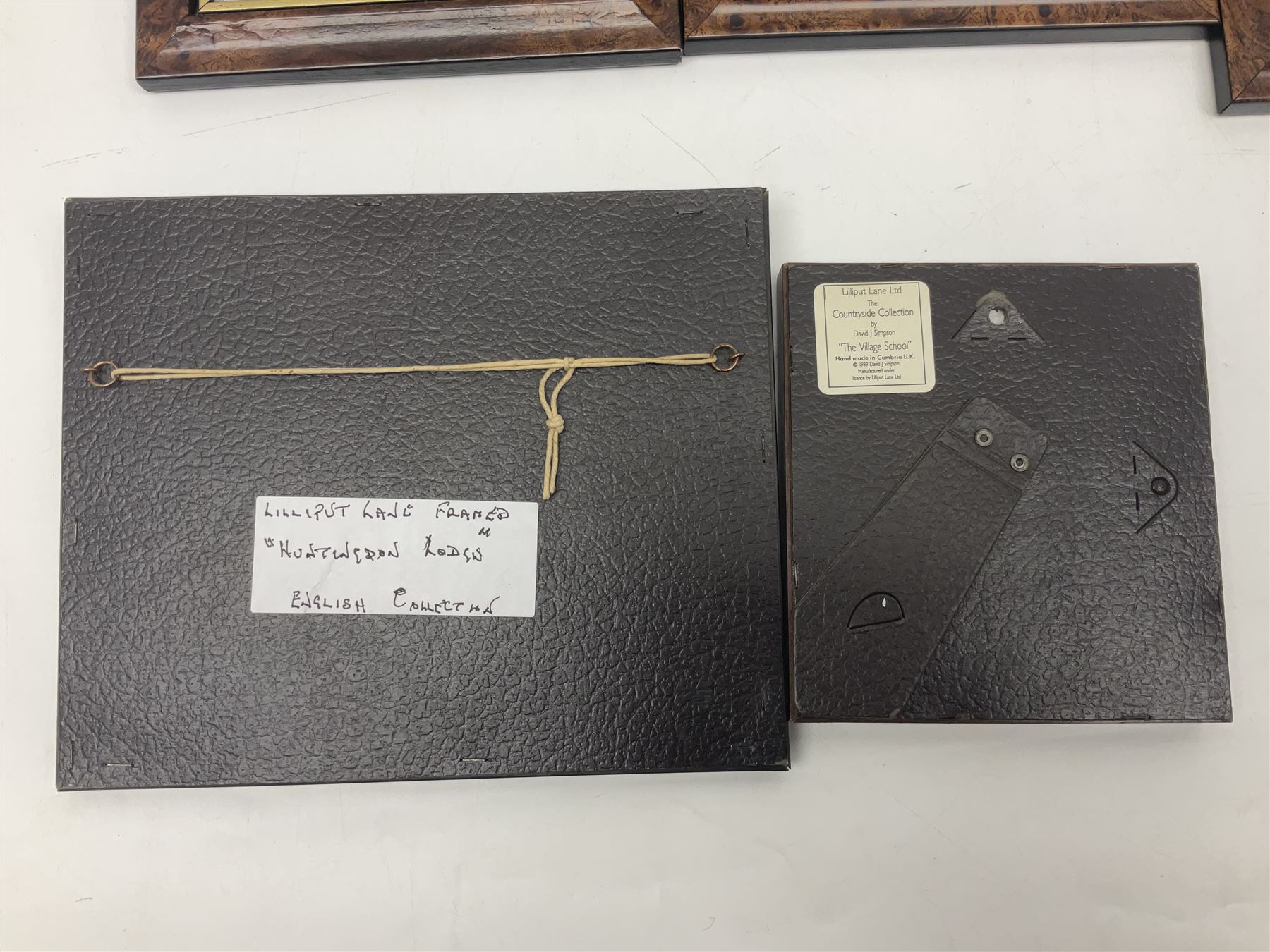 Nine Lilliput Lane framed wall plaques, including Fell View, Battleview, Catslide Cottage, Ashdown Hall and Shannon's Bank, together with three smaller circular framed Lilliput Lane plaques