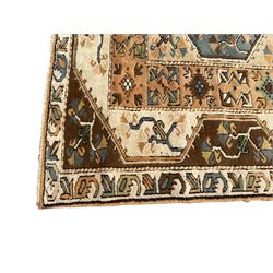 Turkish ivory ground rug, central amber field with lozenges and stylised flower motifs, surrounded by multiple bands with overall geometric design 
