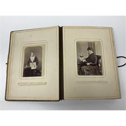  Victorian leather bound photo album, the interior leaves containing apertures of various sizes and shapes of portraits surrounded by printed floral designs, with brass clasp and painted gold decoration to edges, H30cm