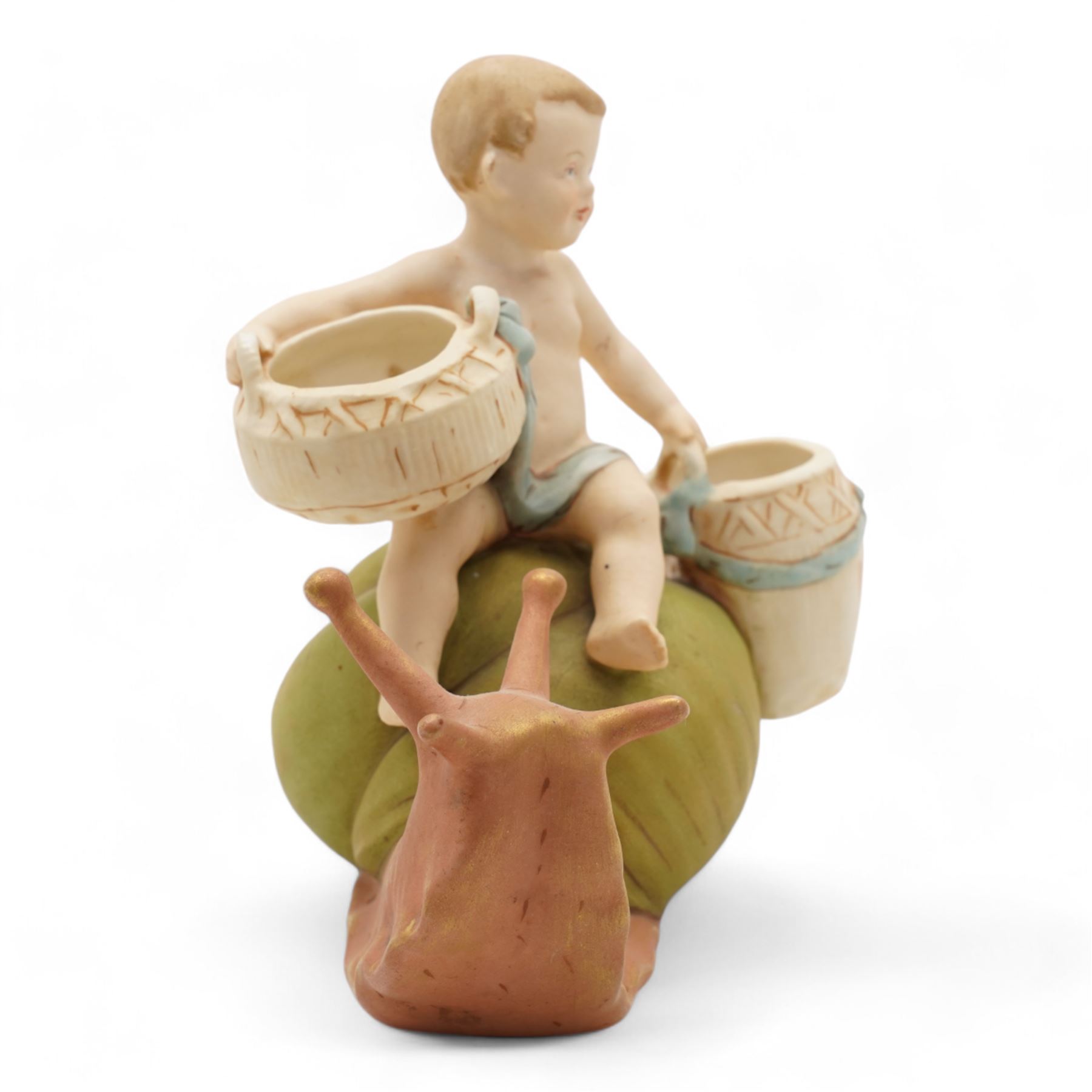 Royal Dux figural posey holder, modelled as a boy with baskets riding a snail, H16.5cm