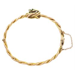 Early 20th century rose gold weave and knot hinged bangle, the central knot with old cut diamond and emerald three leaf clover decoration, stamped 9ct, diamond approx 0.15 carat