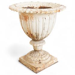 Pair of Victorian white painted cast iron lotus garden urns on stop fluted and lobed plinth bases