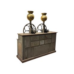 Cabinet with multiple drawers and cupboards mounted with two industrial coffee grinders with large flywheels and brass coffee reservoirs, early 20th century 