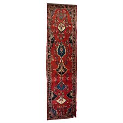 Persian Hamadan runner rug, the vermilion ground decorated with a row of ivory and indigo ...
