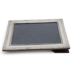 Modern silver mounted photograph frame, of rectangular form with reed and ribbon border, hallmarked Carr's of Sheffield Ltd, Sheffield 2000, together with a silver napkin ring and a silver Port decanter label, both hallmarked, frame H26cm x 21cm