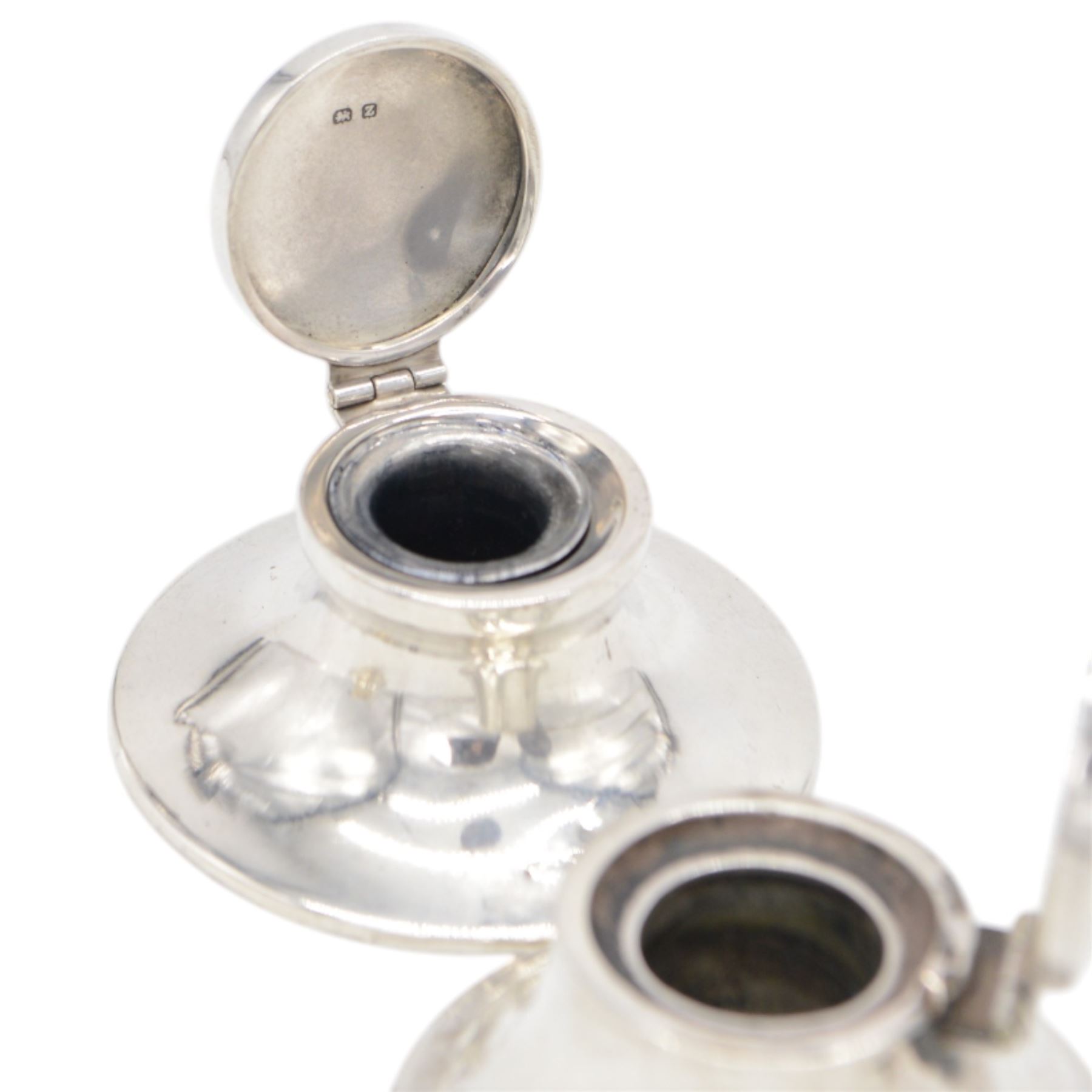 Four early 20th century silver mounted capstan inkwells, all of typical circular form with hinged covers, all hallmarked 