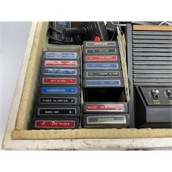 Atari 2600 'Woody' console with various joysticks and controllers etc, and a quantity of game cassettes to include 'Outlaw', 'Air Sea Seattle' and 'Codebreaker' etc housed in white painted wood case