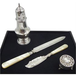 Victorian silver bladed bread knife, with mother of pearl handle by Harrison Brothers & Howson, Sheffield 1897, silver lidded small dressing table box with openwork decoration by Henry Matthews, Birmingham 1911, silver fisher knife with mother of pearl handle and a silver sugar castor, all hallmarked