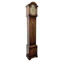 English-1930’s 8-day oak cased grandmother clock, with a break arch hood and trunk with applied carving, brass dial with silvered chapter ring and matted dial centre, three train Westminster chiming movement chiming the quarters and hours on12 gong rods. With pendulum.