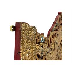 Large North African design carved and painted wall mirror, decorated with floral motifs, pierced foliate scrolls, inset mirrored panels, and colourful painted detailing, enclosing an oval bevelled mirror plate