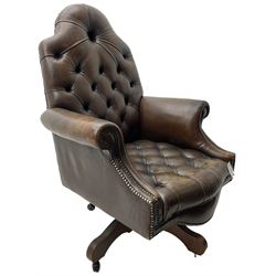 Georgian design office swivel armchair, high arched back over rolled arms and shaped apron, upholstered in deep buttoned dark tan leather with studwork, over swivel and reclining action base
