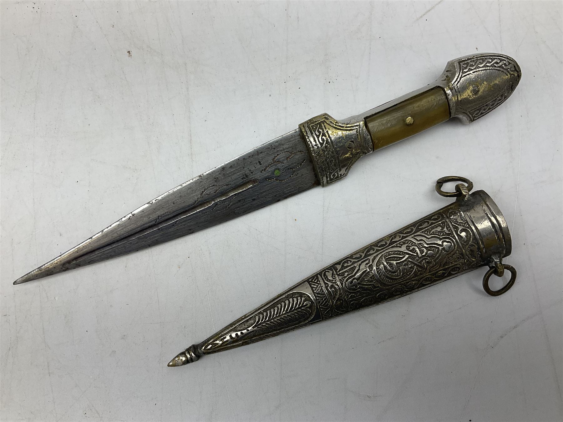 Caucasian qama or kindjal dagger, the 15cm pointed double edged blade with centre fuller and two-piece horn grip;  in nickel plated scabbard with panels of figures and script L28.5cm overall; and eastern knife with 20.5cm curving blade and decorative horn grip; in leather covered scabbard (2)
