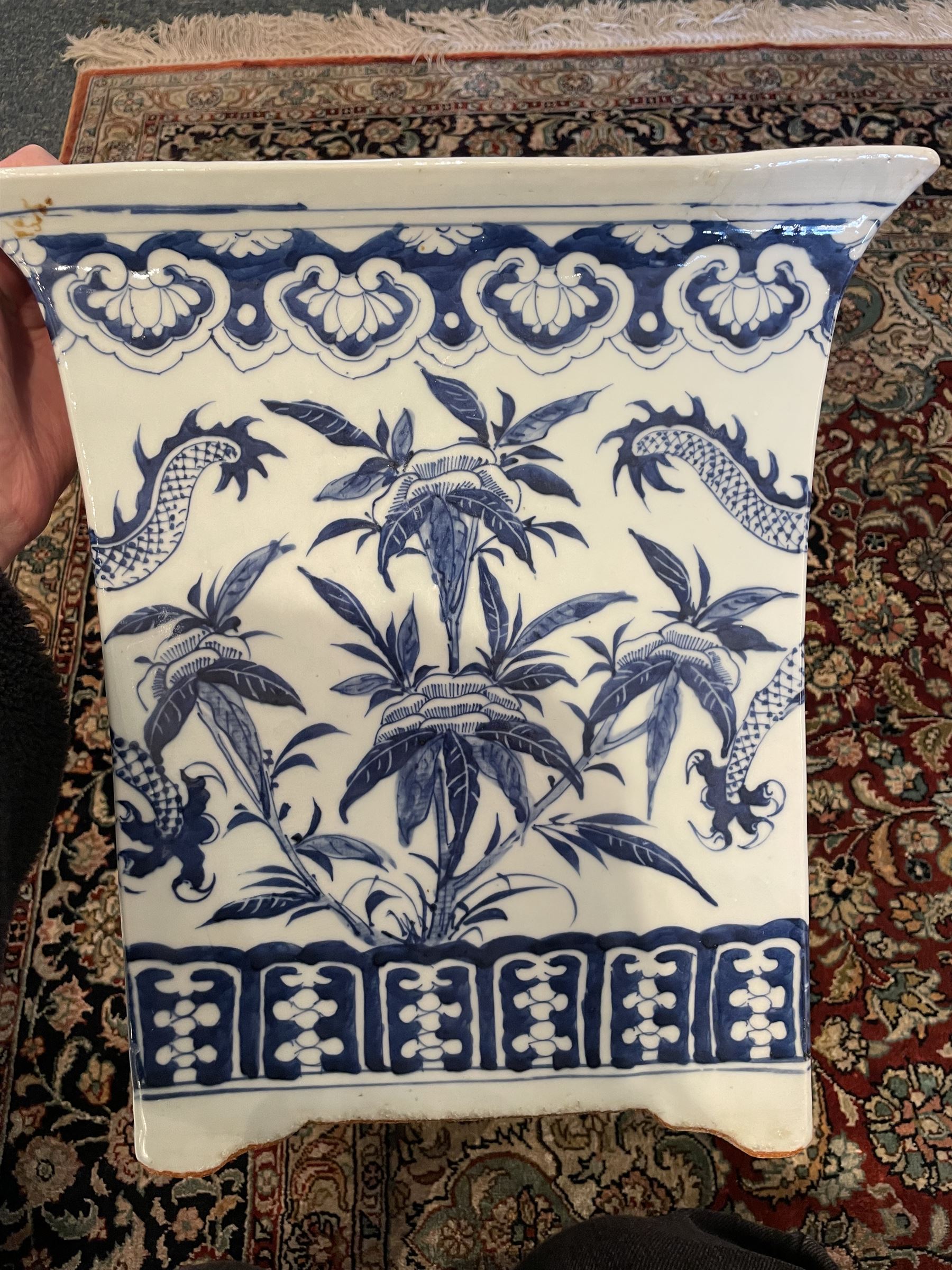 Chinese blue and white planter and stand, each of square slightly tapering and flared form, the planter decorated with two dragons and blossoming peonies, between stylised borders, the stand decorated with flower heads and vines, planter H30cm W29cm, stand H7cm D28.5cm