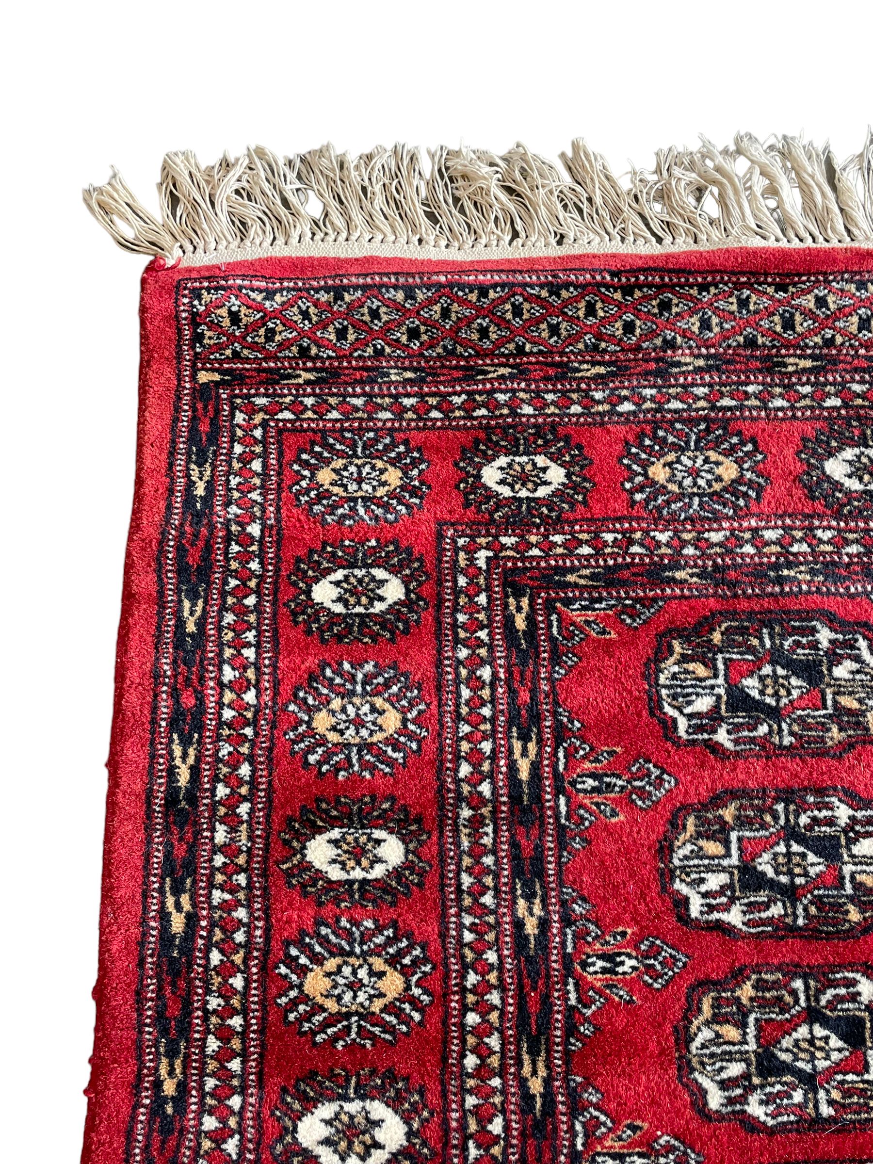 Tekke Bokhara red ground rug, decorated with two rows on Gul motifs, geometric design borders decorated with stylised floral motifs 