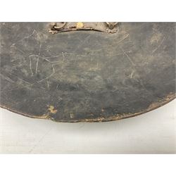 Indian black lacquered hide shield/dhal, of circular convex form fitted at its centre with four pierced iron bosses, each of hemispherical form with wide brims, the bosses corresponding on the inside with four iron rings for enarmes D53.5cm