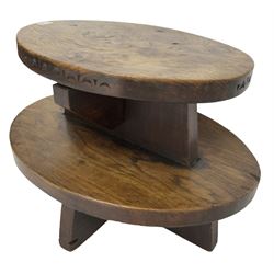 20th century figured elm occasional table, two oval tiers raised on cruciform base, the top tier carved with incised decoration 