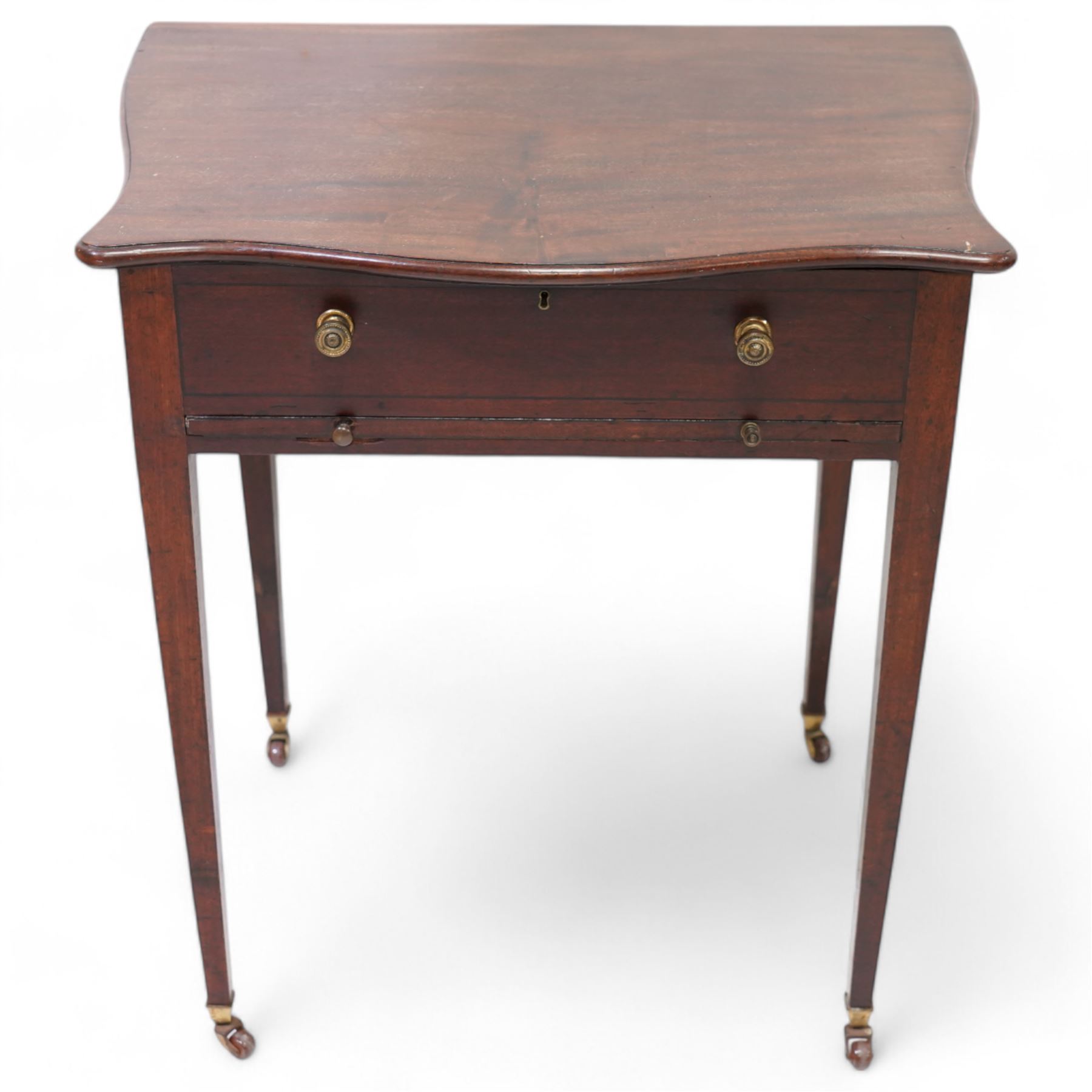 Edwardian mahogany sewing or work table, of shaped form, moulded hinged lid enclosing lidded compartments, fitted with slide, on square tapering supports with brass and ceramic castors 