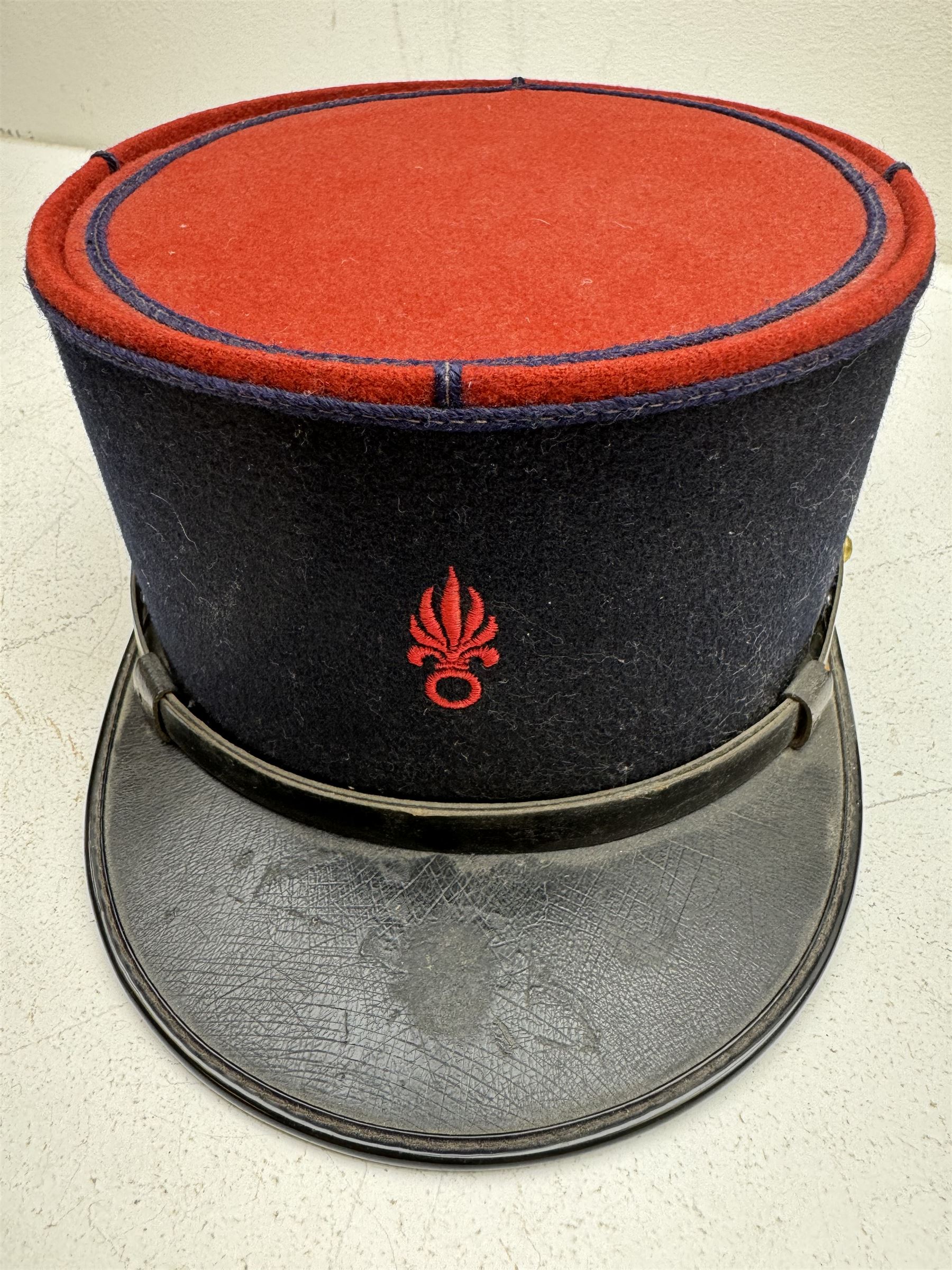 Three French Foreign Legion Kepis; two infantry examples and the third Calvary, each with black peak, original leather sweatband and markers mark stamped inside 