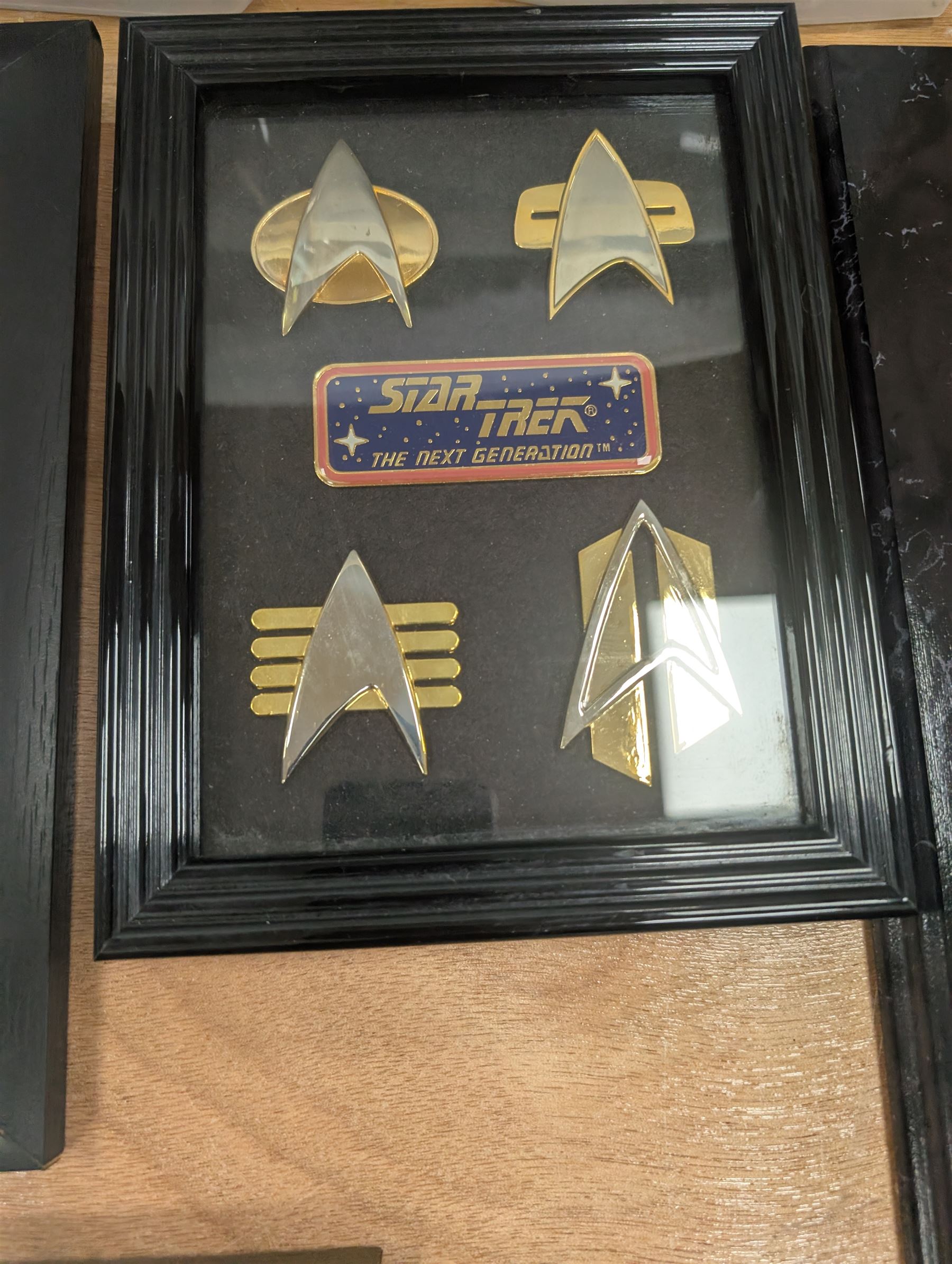 Collection of Star Trek The Next Generation and Deep Space Nine memorabilia, including two limited edition signed Star Trek Deep Space Nine photographs, commemorative porcelain plaque, insignias, Encounter at Farpoint pewter plaque, signed photograph of the Voyager crew, two signed copies of Convergence and a signed War & Madness graphic novel, canvas prints and other signed photos, together with Star Wars Ray Park (Darth Maul) signed photograph, UFO and Buck Rogers memorabilia