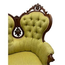 Victorian walnut settee, triple back with pierced and scroll-carved cresting rails over carved fruit and foliage decoration, upholstered in buttoned green fabric, serpentine seat and carved apron, on cabriole feet