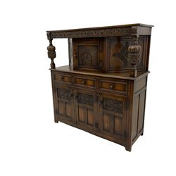 20th century carved oak court cupboard, s-scroll carved frieze over panelled cupboard door carved with arch, lobe and scroll carved cup and cover supports, fitted with three drawers and three cupboards below