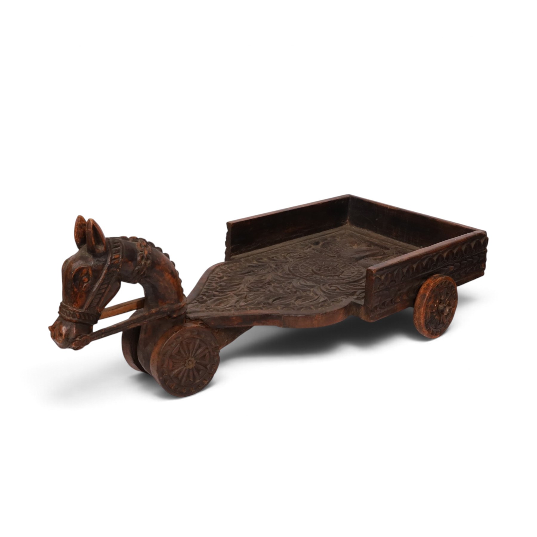 Indian carved wooden tray on wheels, the front carved as a horses head, the cart with foliate details, H28cm