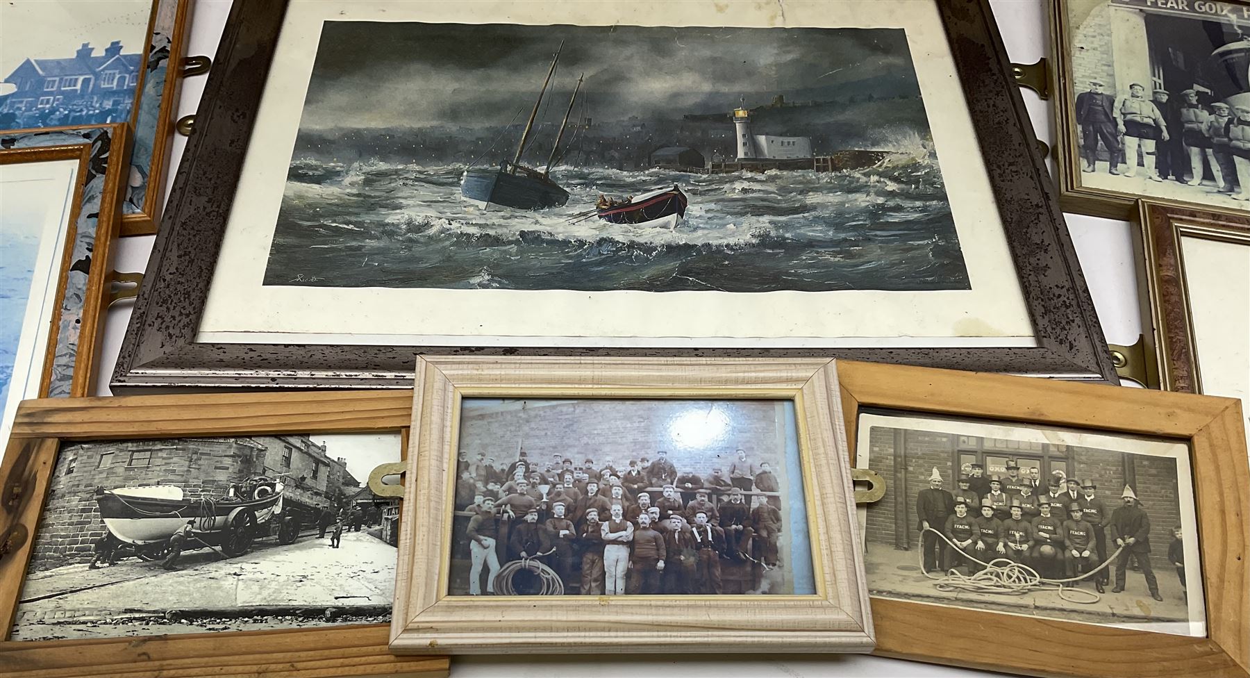 RNLI collection box in the form of a boat makers half block model, painted in the colours of a lifeboat with flag and ship motifs, H25cm, L73cm together with framed photos, postcards and prints of lifeboats and crew, including Scarborough lifeboat station