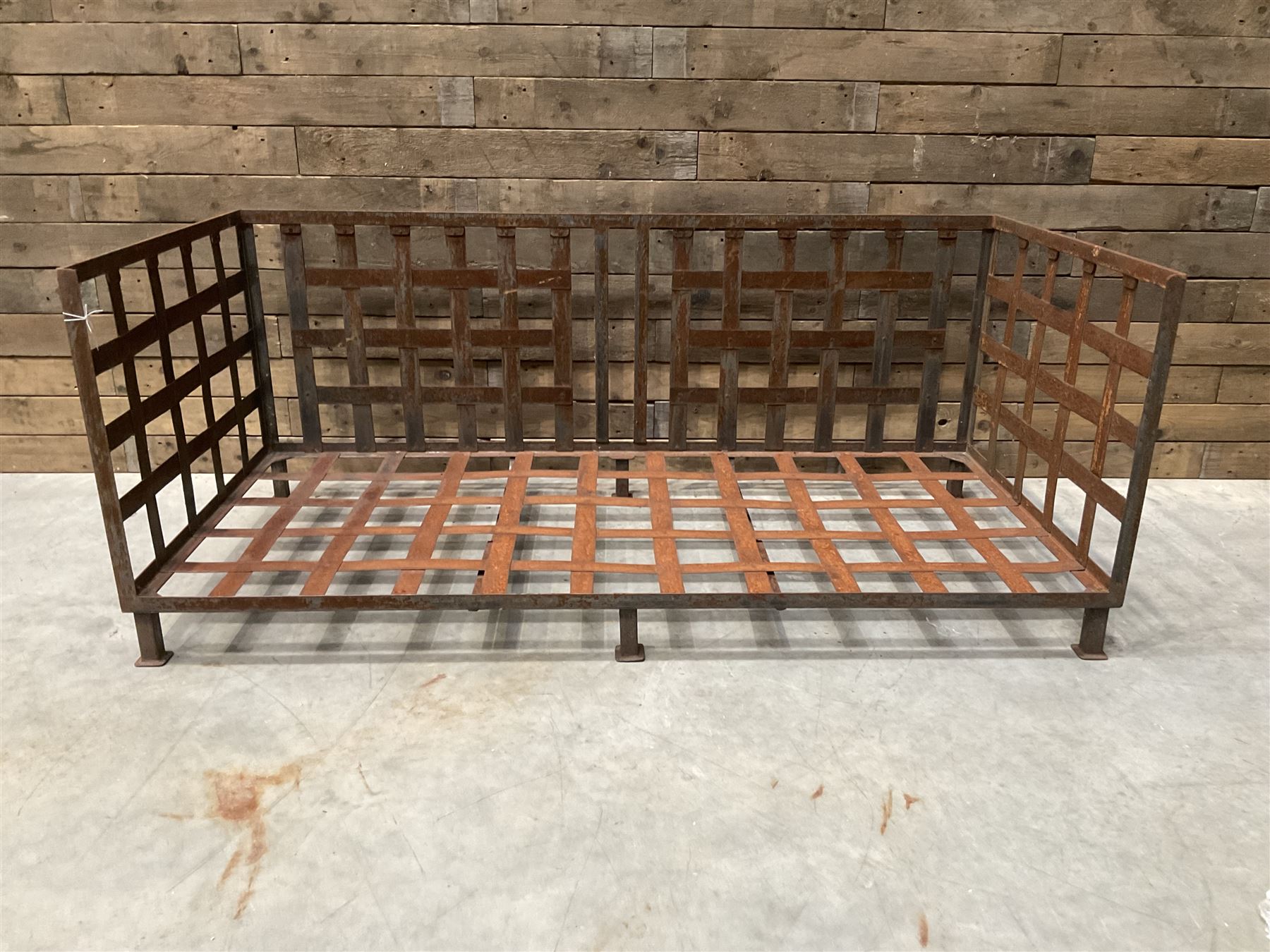 Wrought iron strapwork garden day bed, lattice back and sides