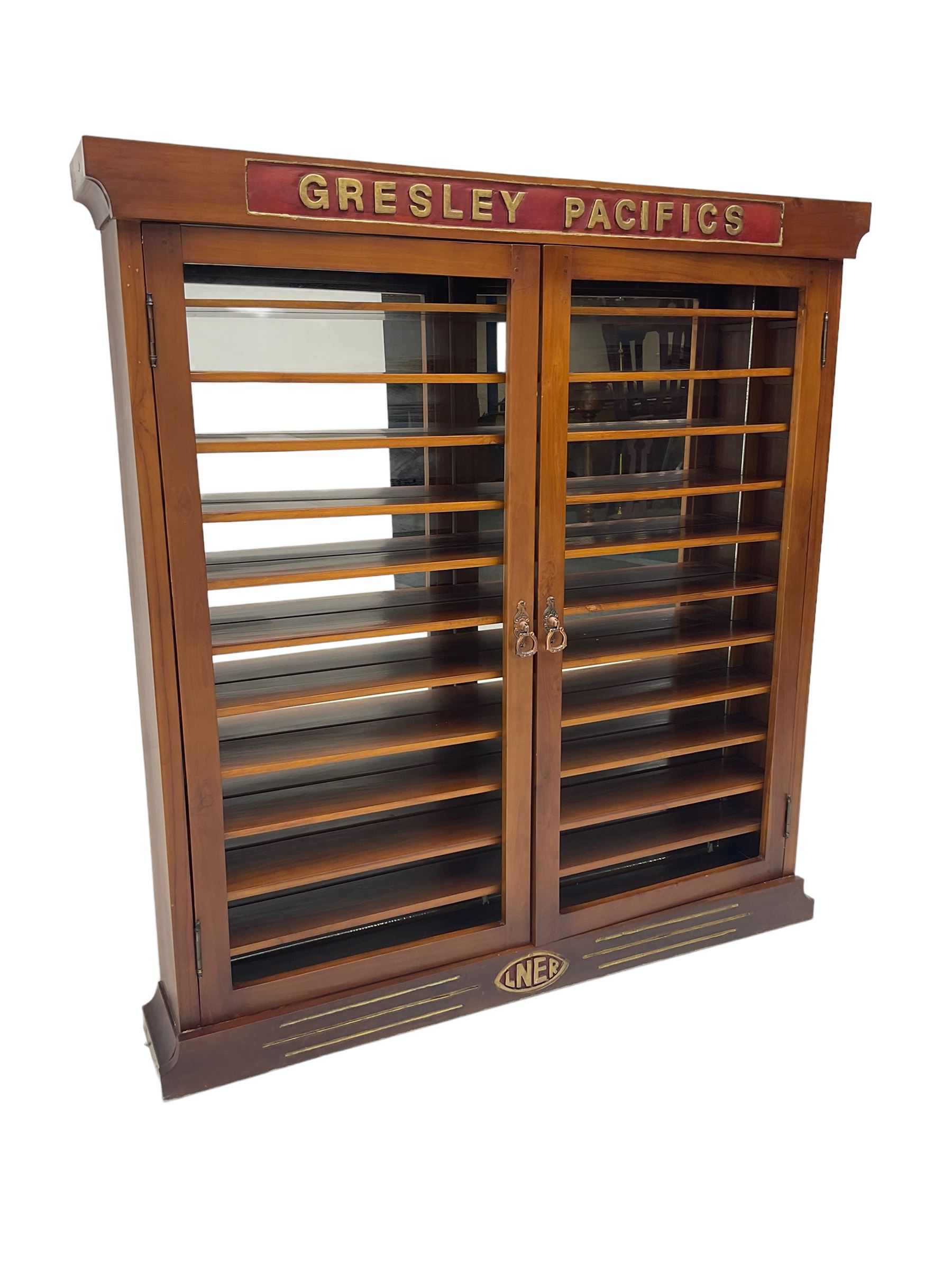 Modern hardwood display cabinet for model railway locomotives inscribed 'Gresley Pacifics' to the frieze and 'LNER' to the bottom rail; with mirrored back and ten loose fitting shelves enclosed by a pair of unglazed doors L101cm H108cm D16cm