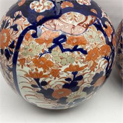 Pair of large 19th century Japanese Imari porcelain bottle vases, painted with shaped reserves of peonies, chrysanthemums and prunus blossom, each H46cm