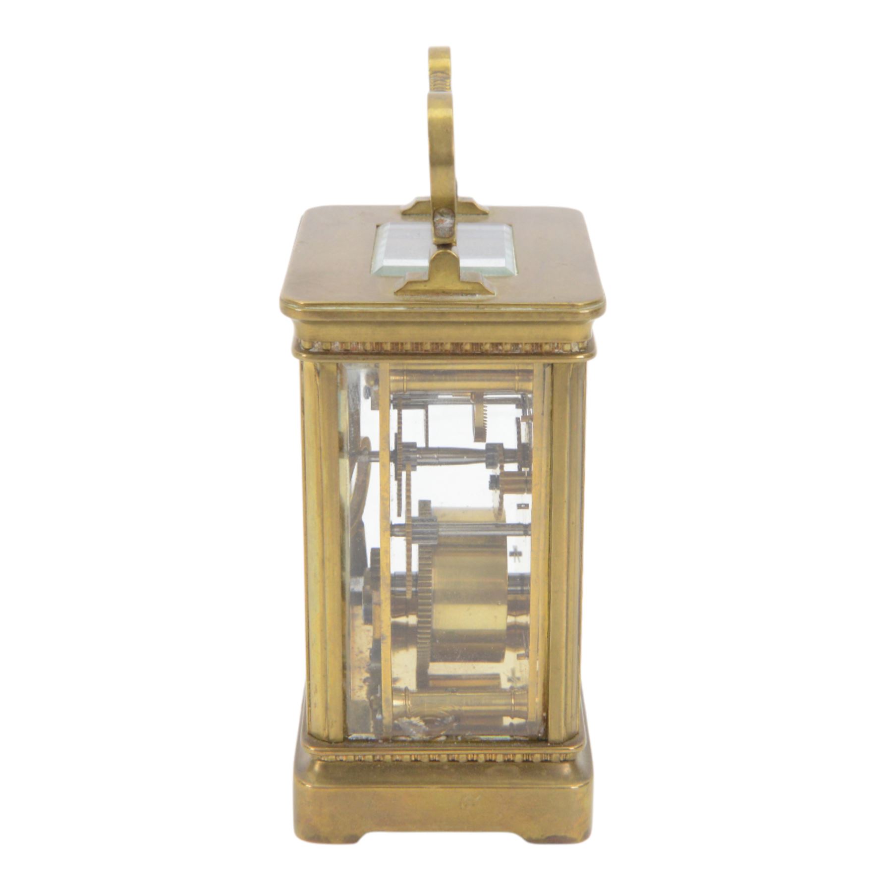 French-Edwardian 8-day timepiece carriage clock with a cylinder platform escapement, anglaise style brass case with four glass panels, dial with a polished gilt mask and foliate decoration, white enamel chapter with Arabic numerals and steel spade hands, . With Key. 