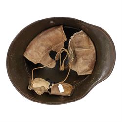 WWI German camouflage M17 helmet, with camouflage painted finish to the skull in green, brown and ochre colours with black separation lines, the interior with leather band which supports three pad leather lining, the pads stamped with indistinct marks 