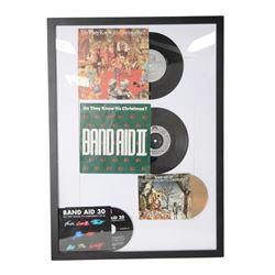 Band Aid vinyls and CDs in framed display, including original Do They Know Its Christmas? and later editions Band Aid II, Band Aid 20 and Band Aid 30, together with limited edition 40th anniversary edition Feed The World 12