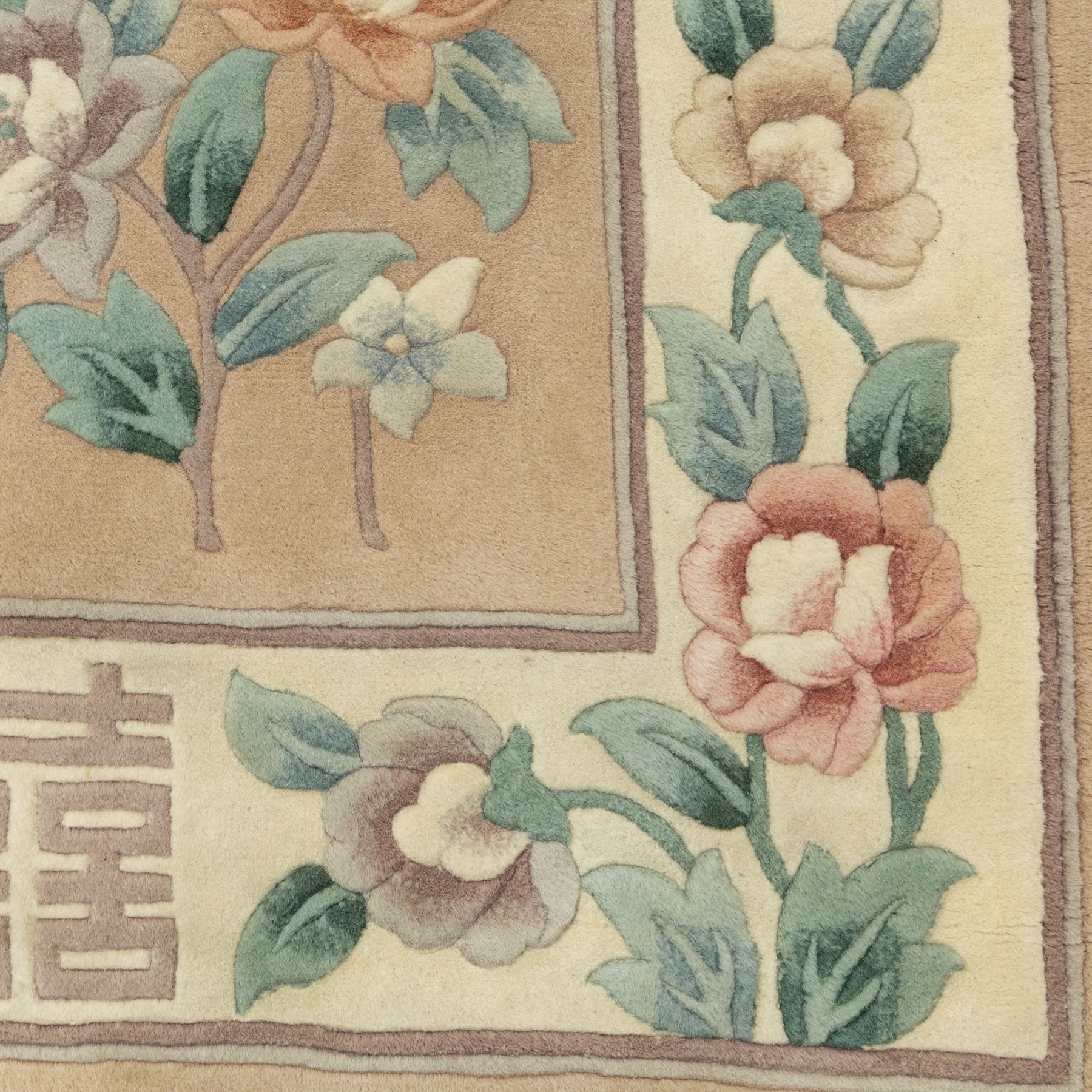 Chinese wool rug, beige ground decorated with peonies, flowering branches and butterflies, centred by a shou symbol within key pattern surround, cream border with floral sprays and double happiness motifs, cotton fringe ends
