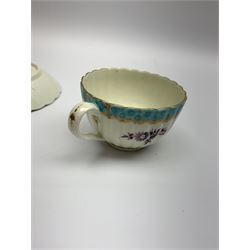 18th century Worcester teacup and saucer, circa 1775-1780, of fluted form hand painted with floral sprays in puce and further floral sprig to interior of cup and centre of saucer, within turquoise and gilt scroll borders, cup with remnants of paper label beneath, cup D8cm saucer D13.5cm