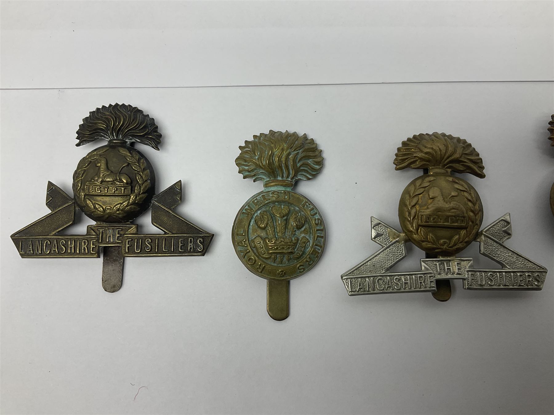Nineteen Yeomanry metal cap badges including Derbyshire, Northamptonshire, Essex, Glamorgan, Staffordshire, City of London, Surrey, Shropshire, Hertfordshire etc; together with eleven Fusiliers badges including Lancashire, Royal Welch, Northumberland etc (30)