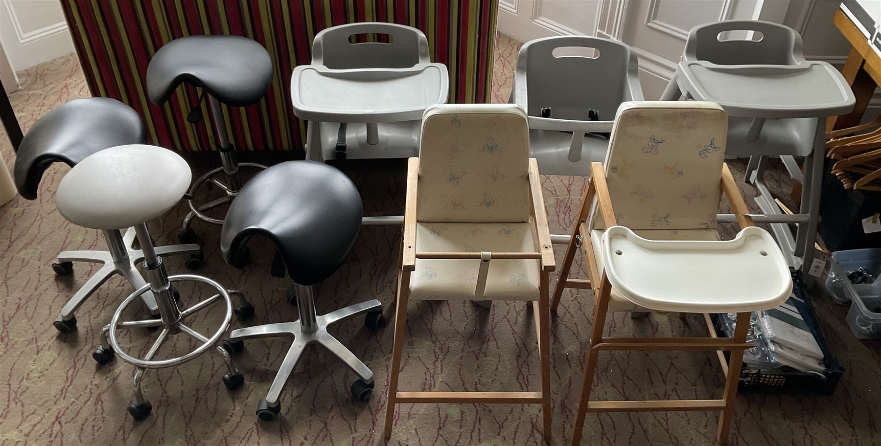 Set of three plastic and a pair of wooden baby high chairs with additional saddle stools (9)- LOT SUBJECT TO VAT ON THE HAMMER PRICE - To be collected by appointment from The Ambassador Hotel, 36-38 Esplanade, Scarborough YO11 2AY. ALL GOODS MUST BE REMOVED BY WEDNESDAY 15TH JUNE.