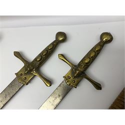 Near pair of short swords each with slightly curving 41cm fullered steel blade and all brass H-shaped hilt L52cm overall; plaited black leather whip; and reproduction pair of brass hilted swords, brass halberd blade and mace (7)