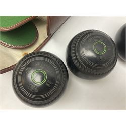Eight Greenmaster lawn green bowling balls, comprising set of four size 5 examples and set of four size 4 examples, and faux leather carrying case