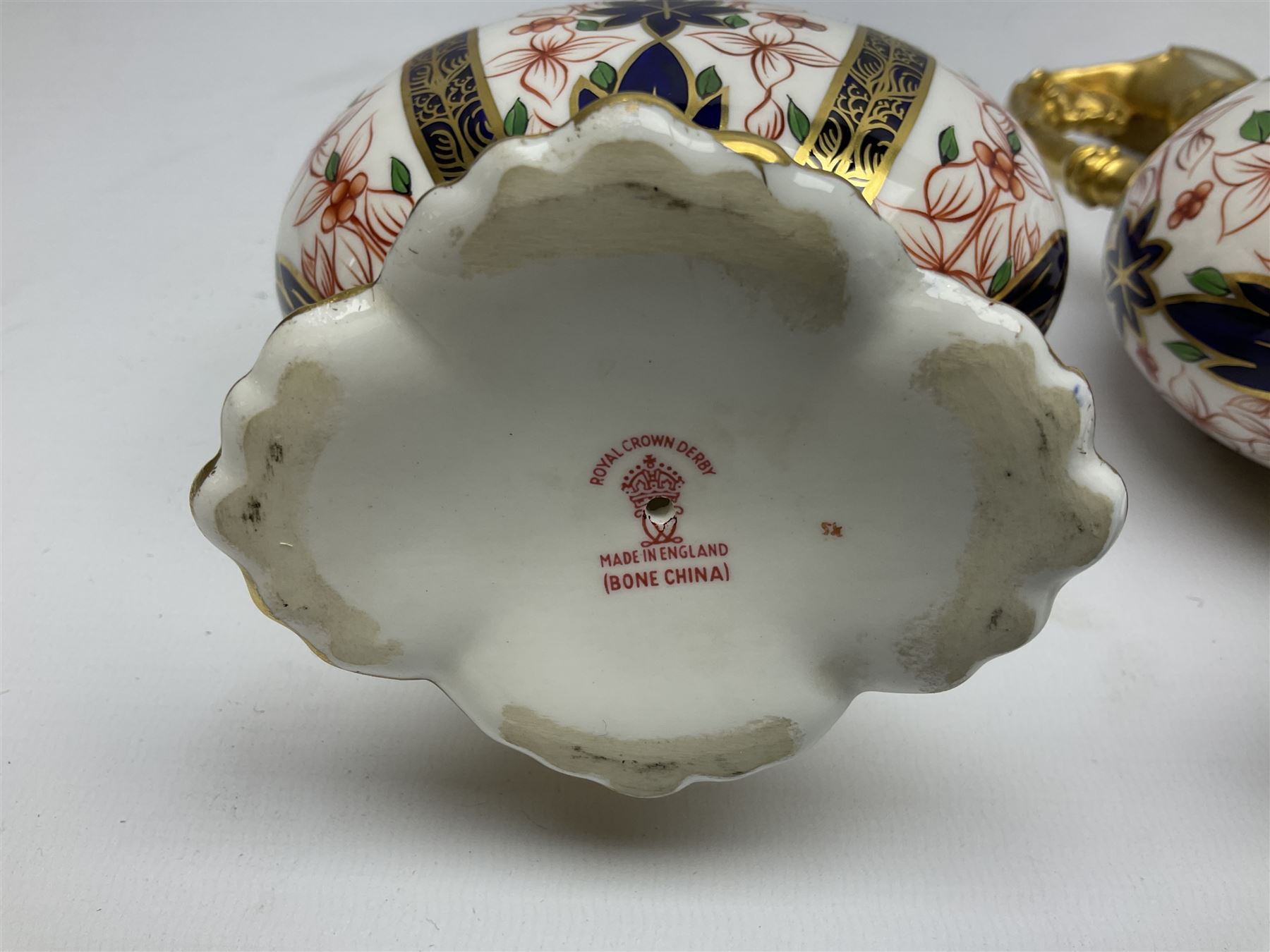 Pair of mid 20th century Royal Crown Derby Imari 1128 pattern Kedleston ewers, each with gilt scroll handle and neck, upon a gilt quatrefoil foot, each with printed marks beneath, H25.5cm