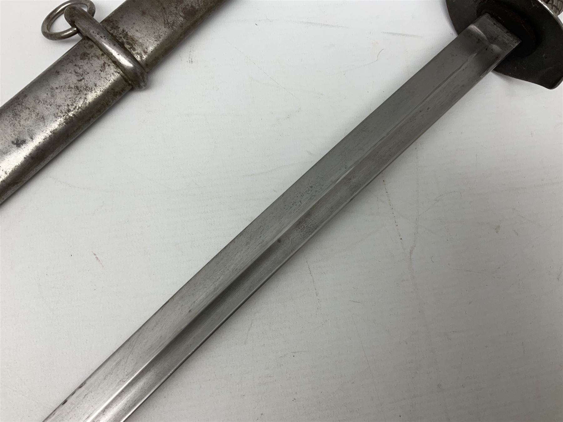 WW2 Japanese Model 1899 Type 32 'Ko' pattern cavalry sword, with 82.5cm single edged, slightly curved blade with narrow fuller, numbered 33825 to the ricasso; steel hilt with chequered backstrap and grip ears with wooden chequered grip and leather finger loop; locking action; in steel scabbard with single hanging ring L99.5cm overall