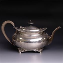 Early 20th century four piece silver tea service, comprising teapot, hot water pot, open sucrier and milk jug, all of oval bellied form with oblique gadrooned rim and upon four feet, the hotwater and teapot with wooden handles and finials, hallmarked William Lister & Sons, Sheffield 1912